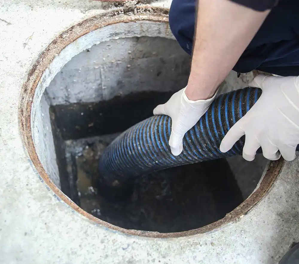 Vide de fosse septique résidentiel par un expert tenant le tuyau de pompage